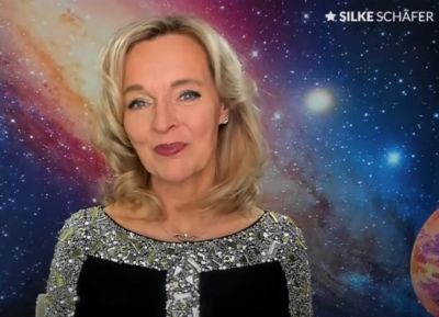 Silke Schäfer im Vortrag zur Zeitenwende 2022 / 2023, im Hintergrund Planeten und Sterne
