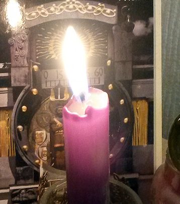 Brennende Kerze vor Accessories und Postkarte aus Wien
